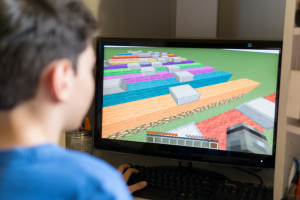 Young boy playing a video game similar to Minecraft