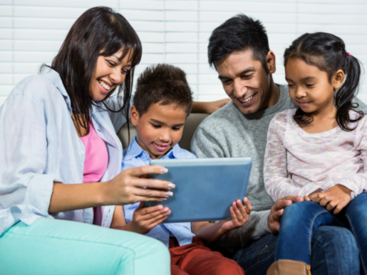 Family looking at a tablet computer together ad smiling