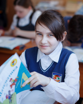 a young girl in a school uniform with a book