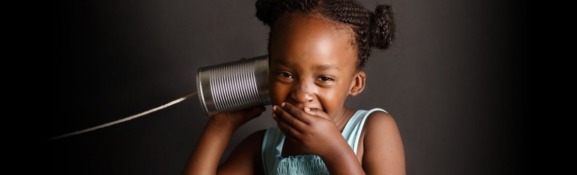 child with a can on a string phone