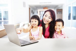 mother with children happily using a laptop
