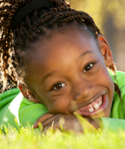 girl smiling while lying in the grass