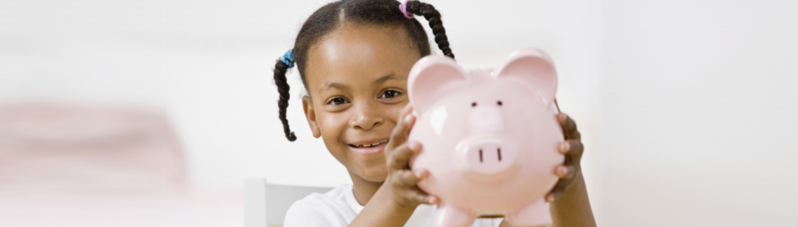 Responsible girl putting money into piggy bank for future savings