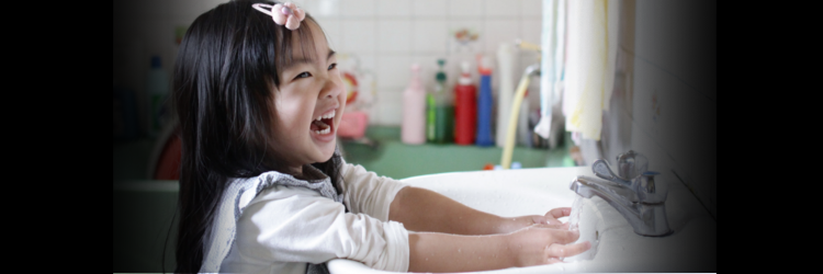 Little girl washing hands in a sink