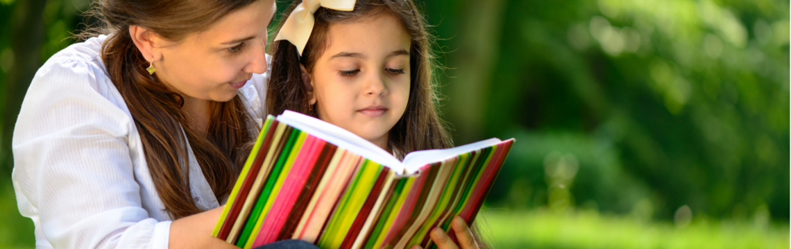 Mother showing her daughter a book