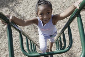 Young girl playing on playground equipment