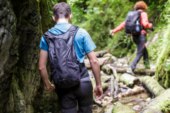 Teen boy wearing a backpack walking through the woods
