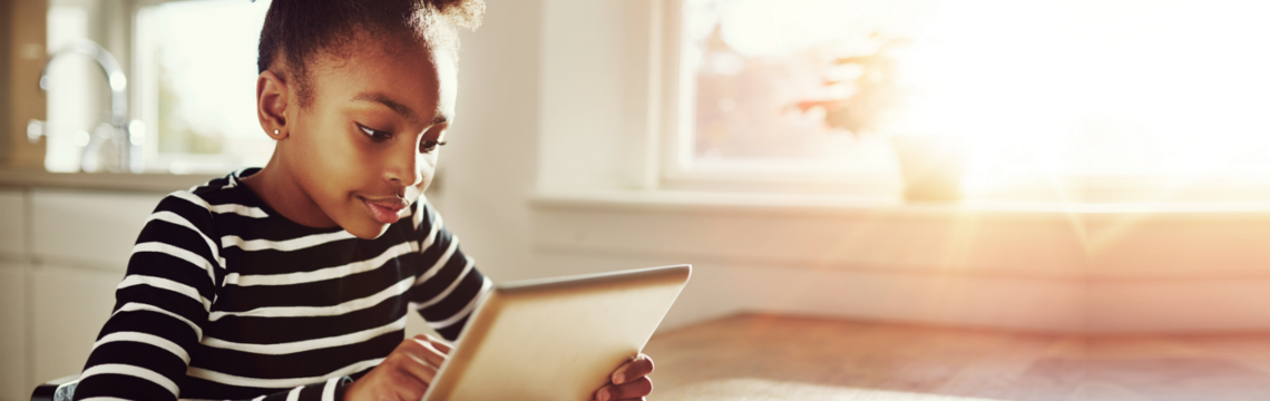 sunlit child with a tablet