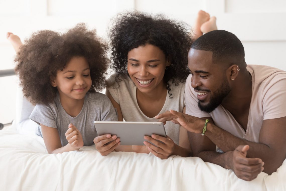 Young family smiling with a tablet