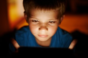 small child lit by screen glow