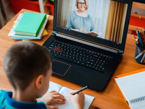 a child learning from a teacher over video from home